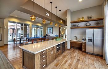 A kitchen with wooden floors and a large island.at Century Cedar Hill, Cedar Hill, 75104